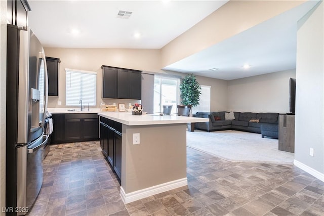 4376 Latitude Valley Ct, North Las Vegas, NV 89084 - kitchen with stainless steel fridge, a sink, light countertops, open floor plan, and lofted ceiling