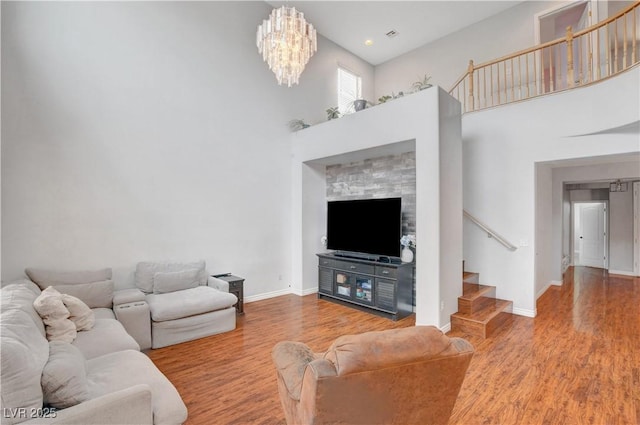 5642 Breckenridge St, North Las Vegas, NV 89081 - living area with stairway, a towering ceiling, wood finished floors, baseboards, and a chandelier