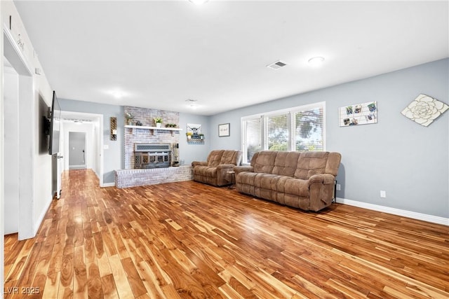 7545 Constantinople Ave, Las Vegas, NV 89129 - living room with light wood finished floors, a brick fireplace, and baseboards