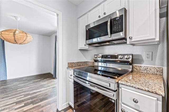 753 Oakmont Ave Unit 802, Las Vegas, NV 89109 - kitchen with stainless steel appliances, wood finished floors, white cabinetry, and light stone counters