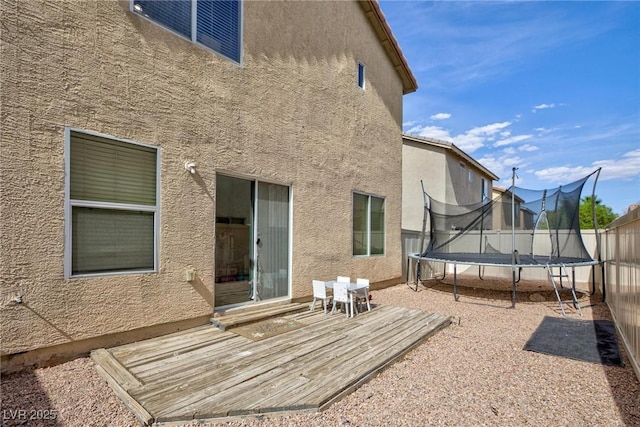 9039 Alex Creek Ave, Las Vegas, NV 89149 - rear view of house with a trampoline, stucco siding, and a wooden deck