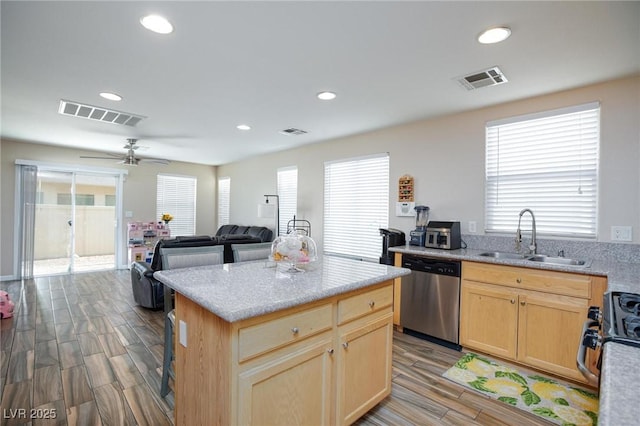 9039 Alex Creek Ave, Las Vegas, NV 89149 - kitchen with stainless steel dishwasher, a sink, wood finished floors, light brown cabinets, and recessed lighting