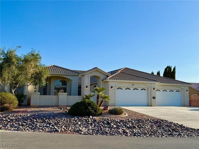 5451 Fernwood Ct, Pahrump, NV 89061 - mediterranean / spanish home featuring an attached garage, driveway, stucco siding, and a tiled roof