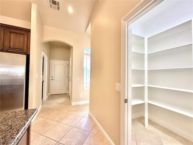 5451 Fernwood Ct, Pahrump, NV 89061 - corridor featuring arched walkways, light tile patterned floors, and baseboards