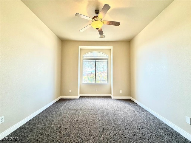 5451 Fernwood Ct, Pahrump, NV 89061 - spare room featuring dark colored carpet, ceiling fan, and baseboards