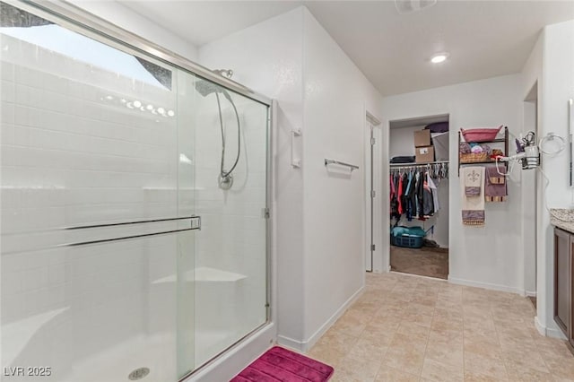 3821 E Summit Ave, Pahrump, NV 89061 - full bathroom with vanity, a stall shower, a spacious closet, and baseboards