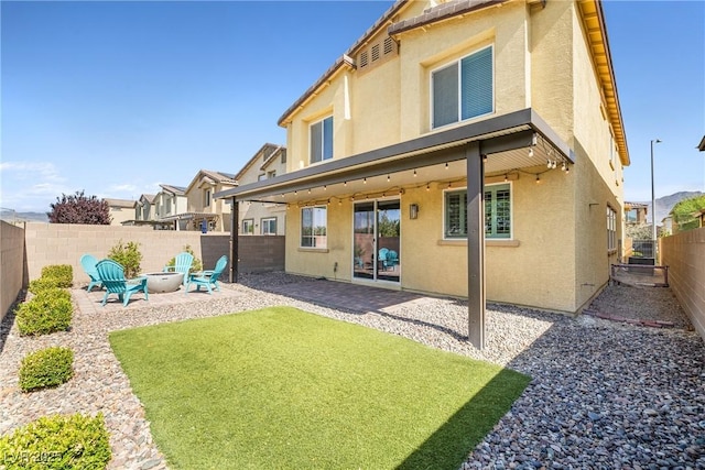 4519 Stardusk Falls Ave, North Las Vegas, NV 89084 - back of house with stucco siding, a patio area, and an outdoor fire pit