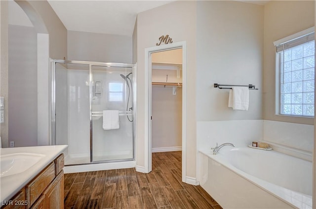 983 Cutter St, Henderson, NV 89011 - full bath with a shower stall, a garden tub, wood finish floors, vanity, and a spacious closet