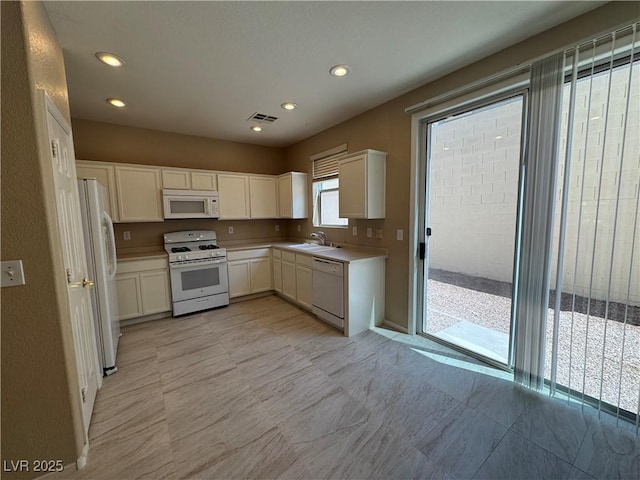 5861 Varese Dr, Las Vegas, NV 89141 - kitchen with white appliances, white cabinets, light countertops, a sink, and recessed lighting