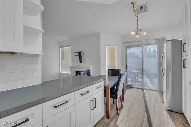 765 Butternut Ct, Henderson, NV 89014 - kitchen featuring freestanding refrigerator, open shelves, white cabinetry, tasteful backsplash, and a textured ceiling