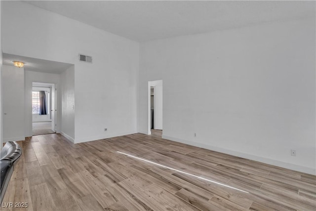 765 Butternut Ct, Henderson, NV 89014 - empty room featuring wood finished floors, a towering ceiling, a baseboard heating unit, and baseboards