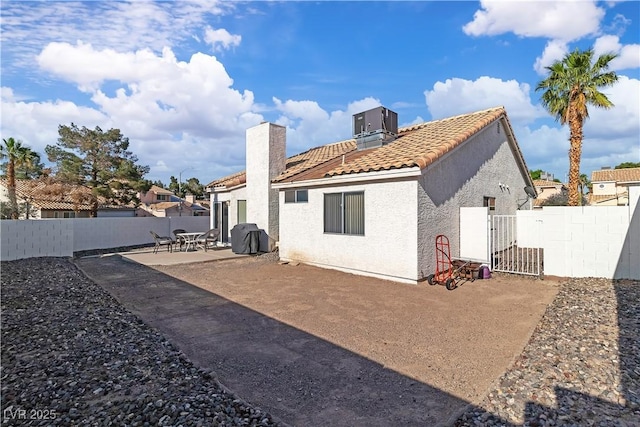 765 Butternut Ct, Henderson, NV 89014 - back of property featuring a tile roof, a fenced backyard, a patio area, stucco siding, and a chimney