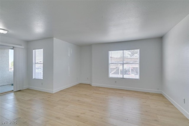 6800 E Lake Mead Blvd Unit 1034, Las Vegas, NV 89156 - spare room with light wood-style flooring, baseboards, and a textured ceiling