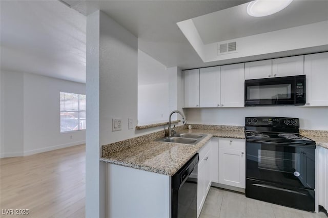 6800 E Lake Mead Blvd Unit 1034, Las Vegas, NV 89156 - kitchen with black appliances, a sink, light stone counters, and white cabinetry