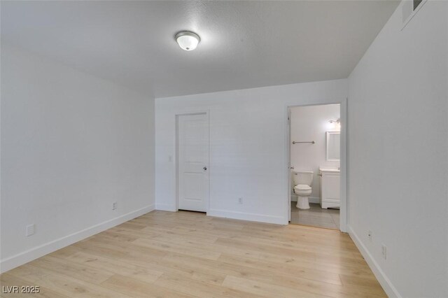 6800 E Lake Mead Blvd Unit 1034, Las Vegas, NV 89156 - unfurnished bedroom featuring light wood-type flooring, baseboards, and ensuite bath