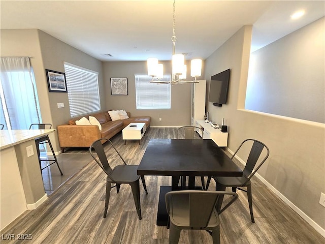 8534 Insignia Ave Unit 101, Las Vegas, NV 89178 - dining room with dark wood finished floors, a chandelier, and baseboards