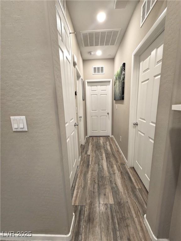 8534 Insignia Ave Unit 101, Las Vegas, NV 89178 - hallway featuring dark wood finished floors, a textured wall, and baseboards