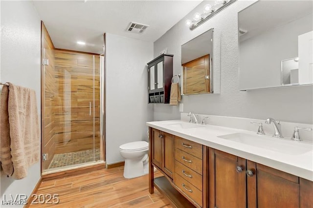 4075 E Oquendo Rd, Las Vegas, NV 89120 - bathroom with double vanity, wood finished floors, toilet, and a stall shower