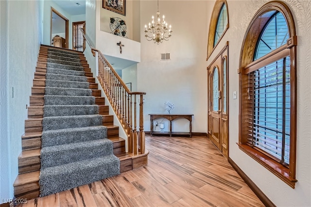4075 E Oquendo Rd, Las Vegas, NV 89120 - foyer with stairway, baseboards, a chandelier, wood finished floors, and a high ceiling