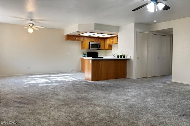 8410 Eldora Ave Unit 2046, Las Vegas, NV 89117 - kitchen with stainless steel microwave, ceiling fan, and open floor plan