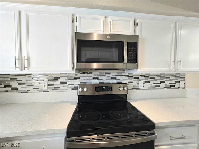 2035 E Warm Springs Rd Unit 1017, Las Vegas, NV 89119 - kitchen with stainless steel appliances, white cabinets, and decorative backsplash