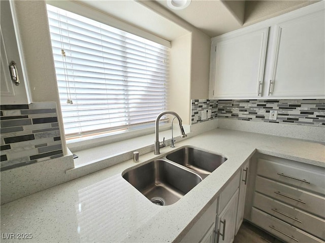 2035 E Warm Springs Rd Unit 1017, Las Vegas, NV 89119 - kitchen with a sink, tasteful backsplash, light stone countertops, and white cabinetry