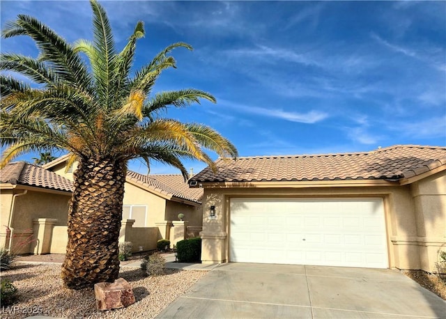 2035 E Warm Springs Rd Unit 1017, Las Vegas, NV 89119 - mediterranean / spanish-style home with concrete driveway, a garage, stucco siding, and a tiled roof
