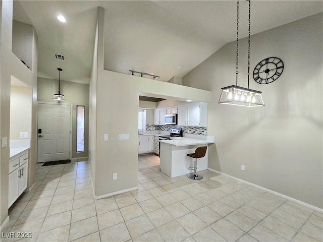 2035 E Warm Springs Rd Unit 1017, Las Vegas, NV 89119 - kitchen with stainless steel appliances, light tile patterned floors, a peninsula, light countertops, and high vaulted ceiling