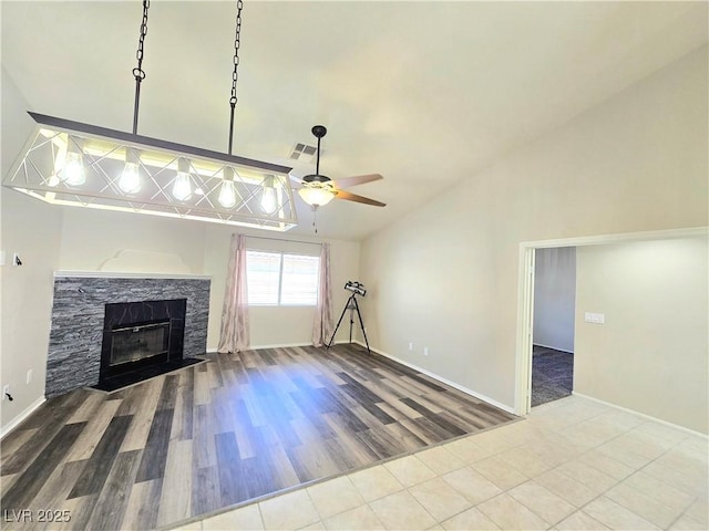2035 E Warm Springs Rd Unit 1017, Las Vegas, NV 89119 - unfurnished living room featuring vaulted ceiling, a ceiling fan, wood finished floors, a glass covered fireplace, and baseboards