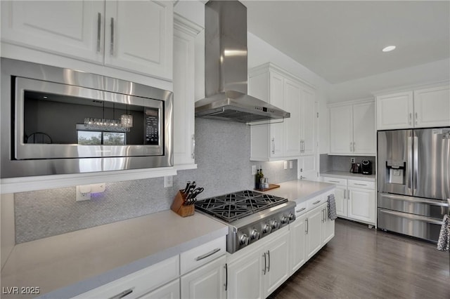 362 Port Reggio St, Las Vegas, NV 89138 - kitchen with appliances with stainless steel finishes, wall chimney range hood, light countertops, white cabinetry, and backsplash