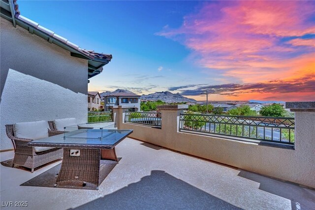362 Port Reggio St, Las Vegas, NV 89138 - patio terrace at dusk with a balcony, a mountain view, and outdoor dining space