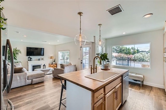 615 D Ave, Boulder City, NV 89005 - kitchen with a sink, stainless steel dishwasher, light wood finished floors, a kitchen breakfast bar, and a fireplace