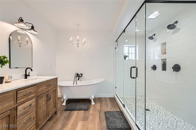 615 D Ave, Boulder City, NV 89005 - bathroom with vanity, a freestanding tub, a stall shower, wood finished floors, and a chandelier