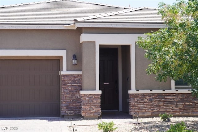 10262 Havasu Falls St, Las Vegas, NV 89141 - property entrance featuring stone siding, stucco siding, a tile roof, and an attached garage