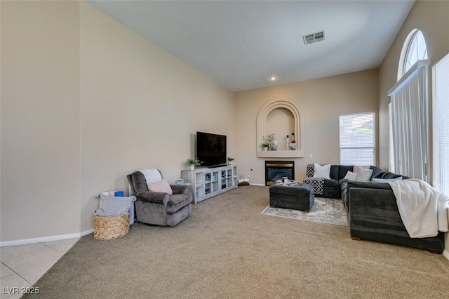 2090 Eaglepath Cir, Henderson, NV 89074 - carpeted living room with baseboards, a glass covered fireplace, tile patterned flooring, and a towering ceiling