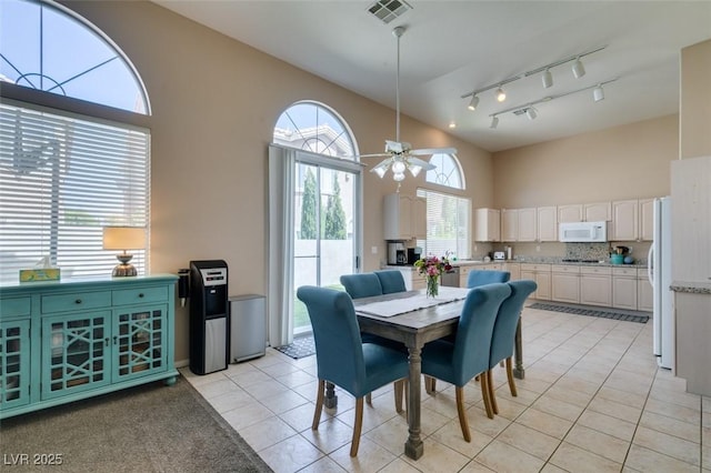 2090 Eaglepath Cir, Henderson, NV 89074 - dining space with high vaulted ceiling, rail lighting, light tile patterned floors, and ceiling fan