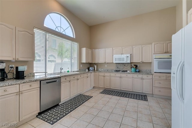 2090 Eaglepath Cir, Henderson, NV 89074 - kitchen featuring white appliances, a towering ceiling, a sink, and light tile patterned flooring