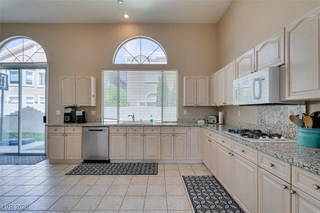 2090 Eaglepath Cir, Henderson, NV 89074 - kitchen with white appliances, light stone countertops, light tile patterned flooring, a towering ceiling, and recessed lighting