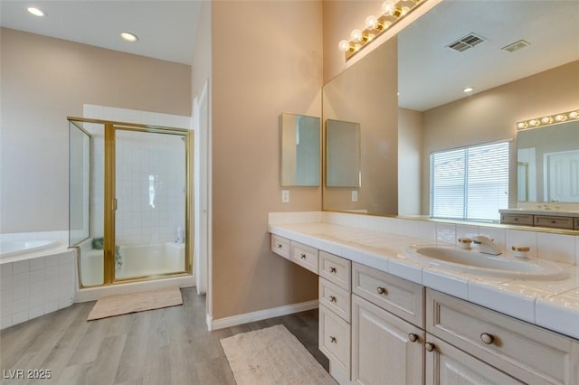 2090 Eaglepath Cir, Henderson, NV 89074 - bathroom with vanity, wood finished floors, a garden tub, a shower stall, and recessed lighting