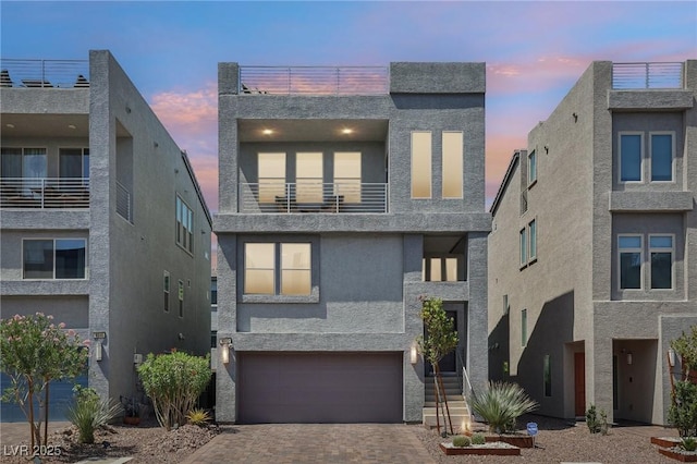 8042 Misty Canyon Ave, Las Vegas, NV 89113 - contemporary home featuring an attached garage, decorative driveway, stucco siding, and a balcony