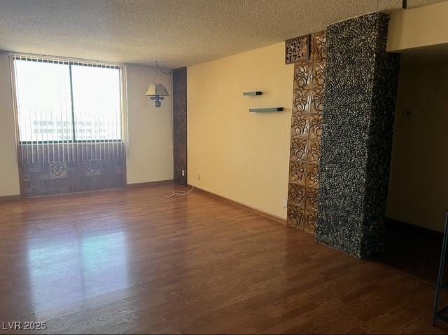 3930 University Center Dr Unit 612, Las Vegas, NV 89119 - empty room featuring dark wood-style flooring and a textured ceiling