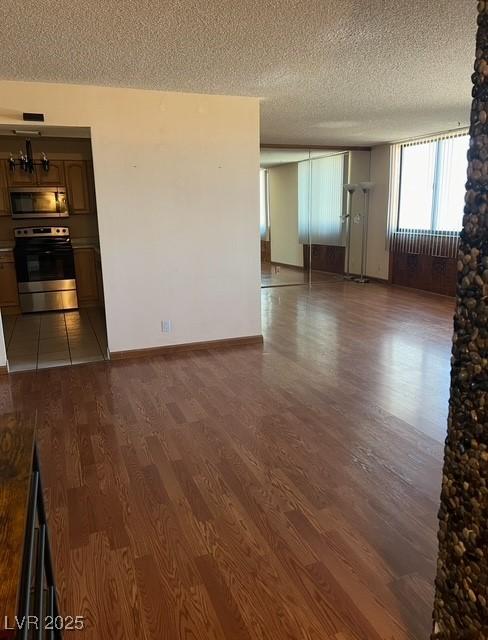 3930 University Center Dr Unit 612, Las Vegas, NV 89119 - empty room featuring dark wood-style floors, a textured ceiling, and baseboards