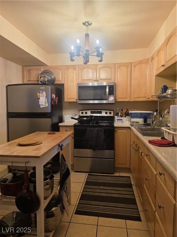 3930 University Center Dr Unit 612, Las Vegas, NV 89119 - kitchen with appliances with stainless steel finishes, light brown cabinets, tile patterned floors, and a chandelier