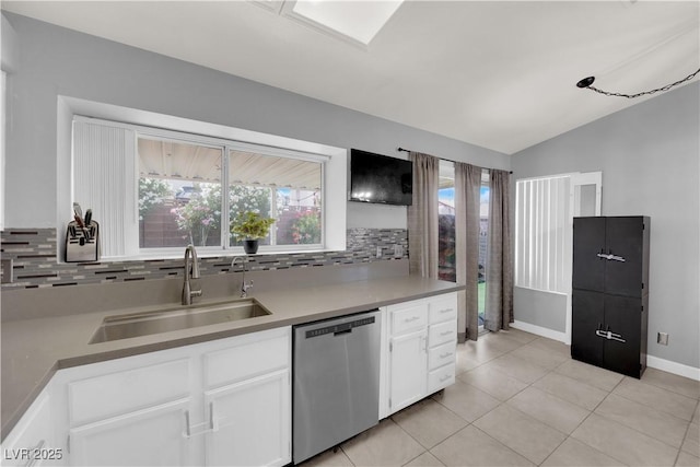 3905 Blairmoor St, North Las Vegas, NV 89032 - kitchen featuring stainless steel dishwasher, a sink, decorative backsplash, white cabinets, and vaulted ceiling