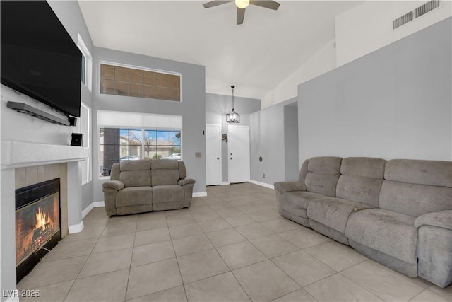 3905 Blairmoor St, North Las Vegas, NV 89032 - living room featuring high vaulted ceiling, a ceiling fan, a tile fireplace, light tile patterned floors, and baseboards