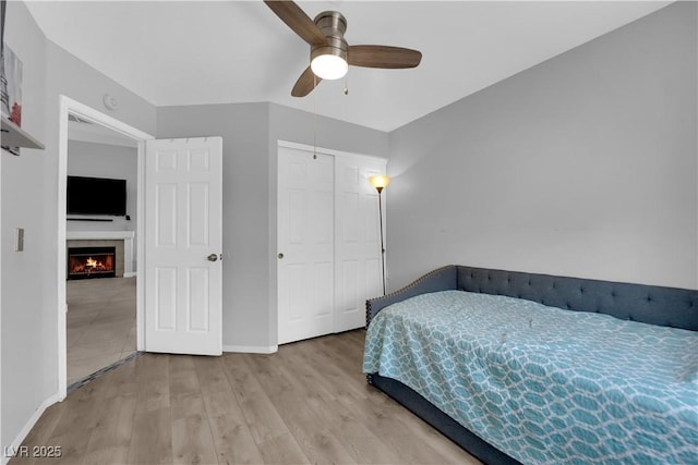 3905 Blairmoor St, North Las Vegas, NV 89032 - bedroom with baseboards, wood finished floors, a ceiling fan, a closet, and a tile fireplace