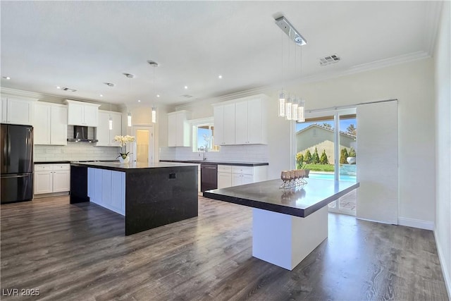 5500 Santovito St, Pahrump, NV 89061 - kitchen with freestanding refrigerator, a center island with sink, dark countertops, crown molding, and dishwashing machine