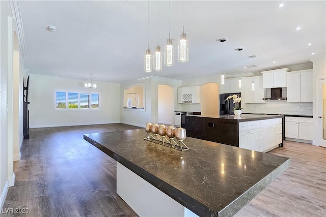 5500 Santovito St, Pahrump, NV 89061 - kitchen featuring a large island, fridge with ice dispenser, baseboards, decorative backsplash, and crown molding