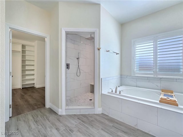 5500 Santovito St, Pahrump, NV 89061 - bathroom featuring a garden tub, a shower stall, wood finished floors, and a walk in closet