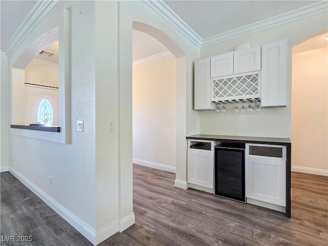5500 Santovito St, Pahrump, NV 89061 - kitchen with beverage cooler, dark wood-style floors, white cabinets, ornamental molding, and baseboards